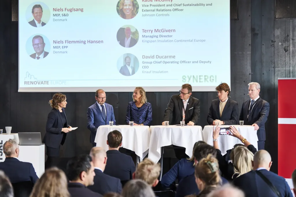 A panel on stage at Renovate Europe Day 2025 in Copenhagen, with the speakers listed on the screen behind them