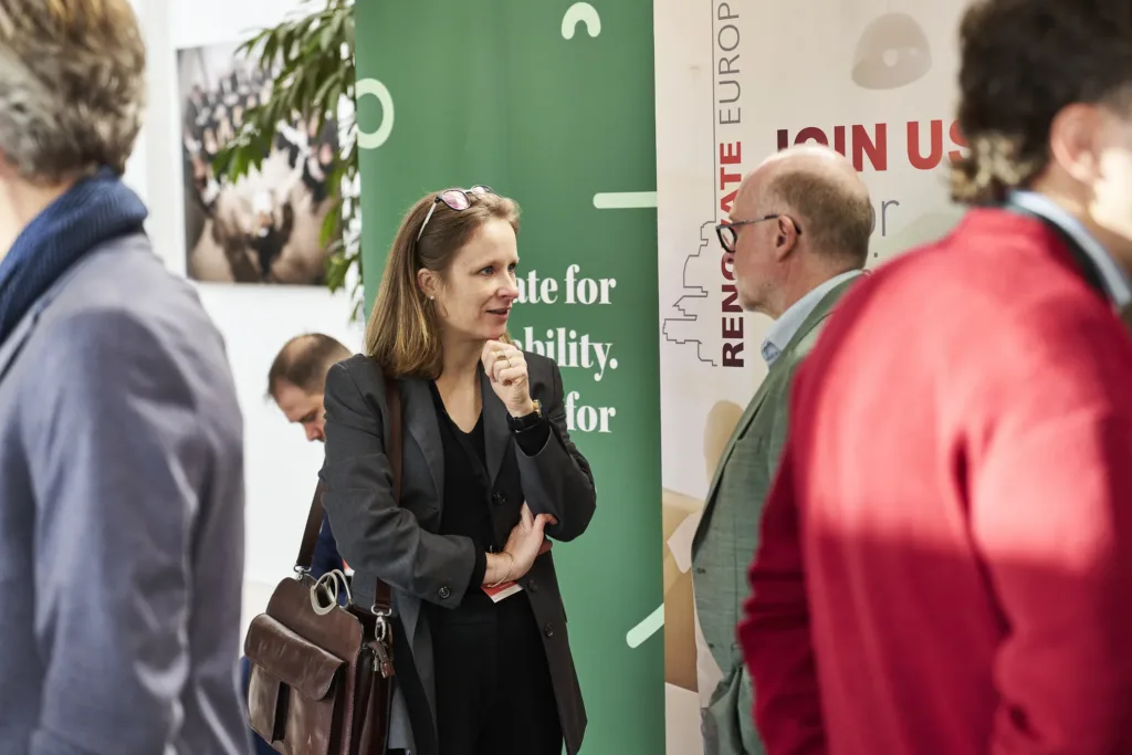 Participants talking beside a Renovate Europe “Join us” banner at Renovate Europe Day 2025 in Copenhagen
