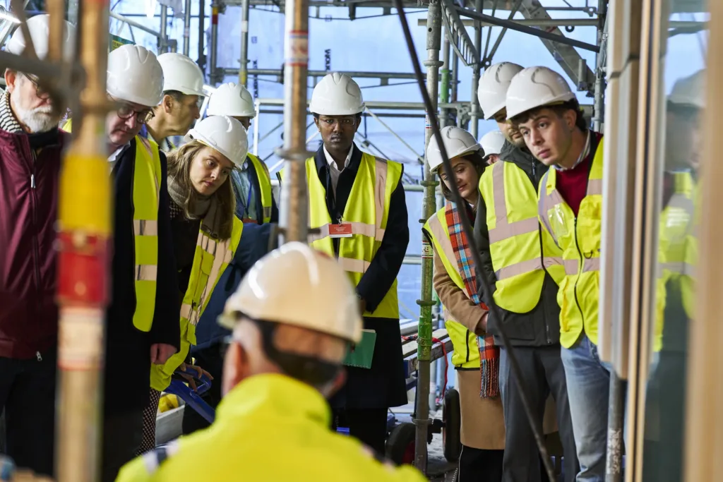 Visitors in hard hats and high-visibility vests on a renovation site at Renovate Europe Day 2025 in Copenhagen