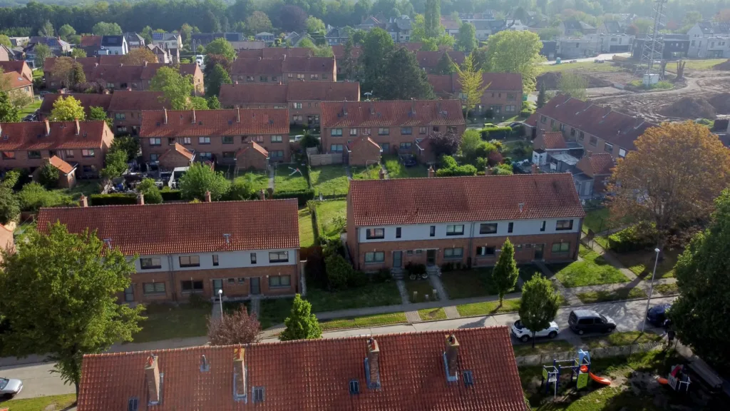 Aerial view of terraced brick houses with red-tiled roofs and gardens in Halle, Belgium.